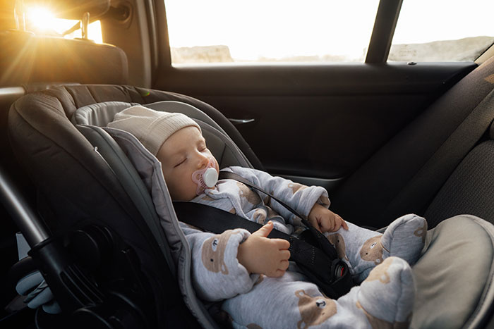 Sleeping baby in car seat during unexpected employee emergency