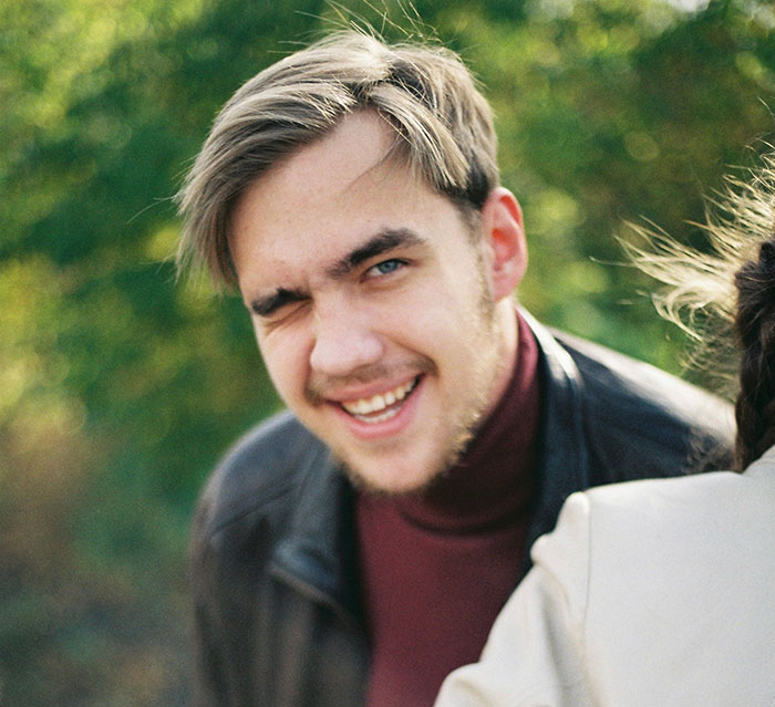 Young man smirking in outdoor setting close up