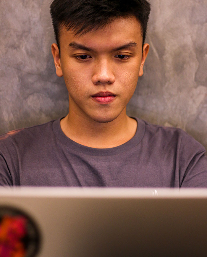 Man focused on laptop screen working or studying indoors