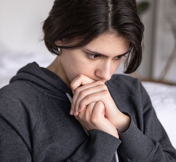 Pensive person in gray hoodie contemplating friendship realization moment