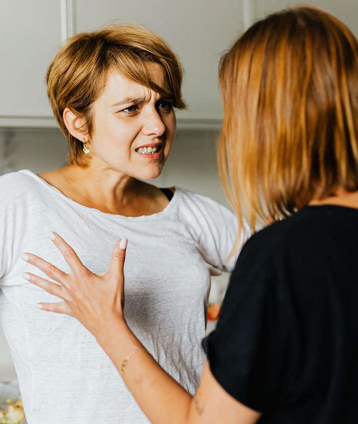 Two women arguing intensely about friendship betrayal