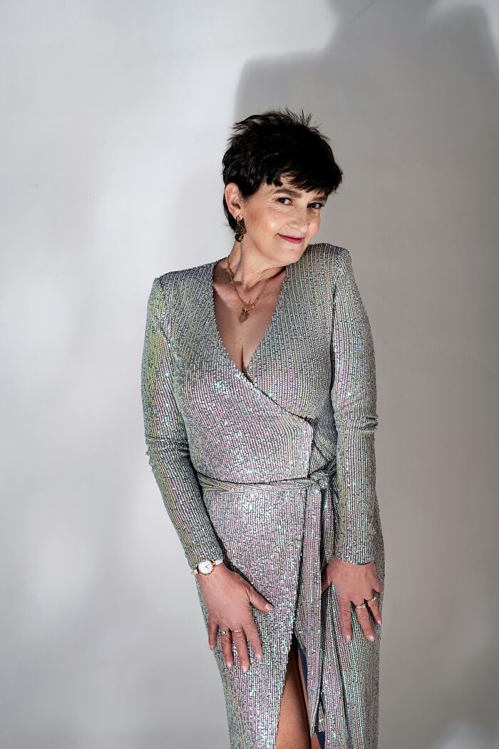 Woman posing in a sparkling silver dress for a wedding guest outfit
