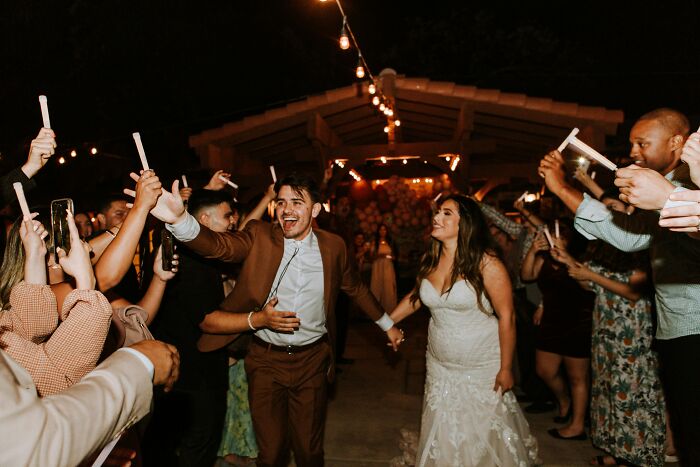 Bride and groom celebrating with guests holding sparklers at night