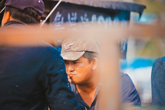 A man in a baseball cap intently looking away, hinting at the shocking double lives people lead.