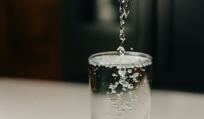 Pouring filtered drinking water into a clear glass