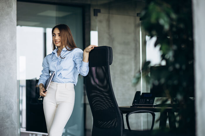 Woman in an office setting, possibly reflecting on an awkward situation at work.