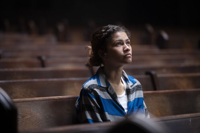 Euphoria character sitting alone on wooden pews in reflective mood Euphoria character sitting alone on wooden pews in reflective mood
