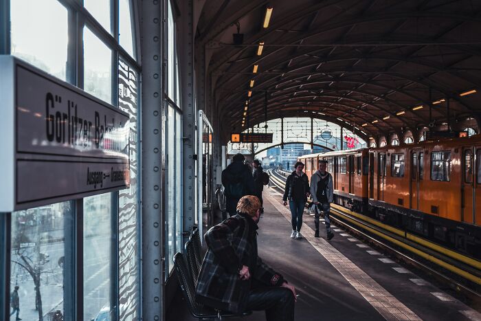 People waiting on platform at train station in cold light of morning