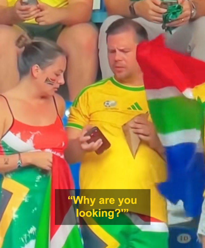 A couple at the World Cup, where the man is engrossed in his phone, leading to a viral World Cup moment. A couple at the World Cup, where the man is engrossed in his phone, leading to a viral World Cup moment.