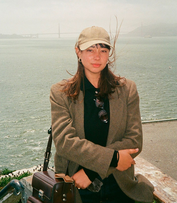 A woman looking at the camera with water and a bridge in the background, making a bombshell discovery about her dad and Charles Manson. A woman looking at the camera with water and a bridge in the background, making a bombshell discovery about her dad and Charles Manson.