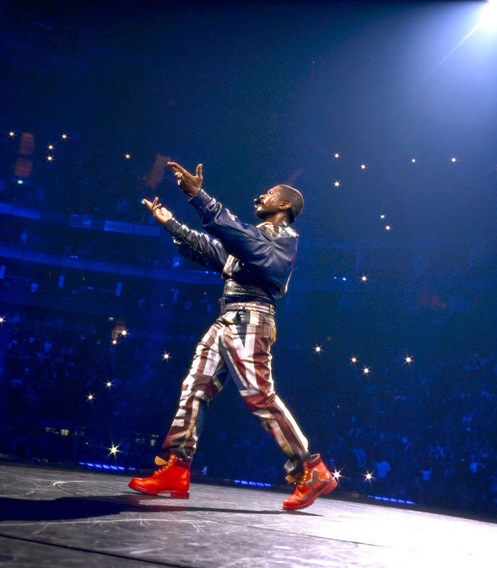 Usher performing on stage, while a woman had an awkward reaction to his seductive moves.