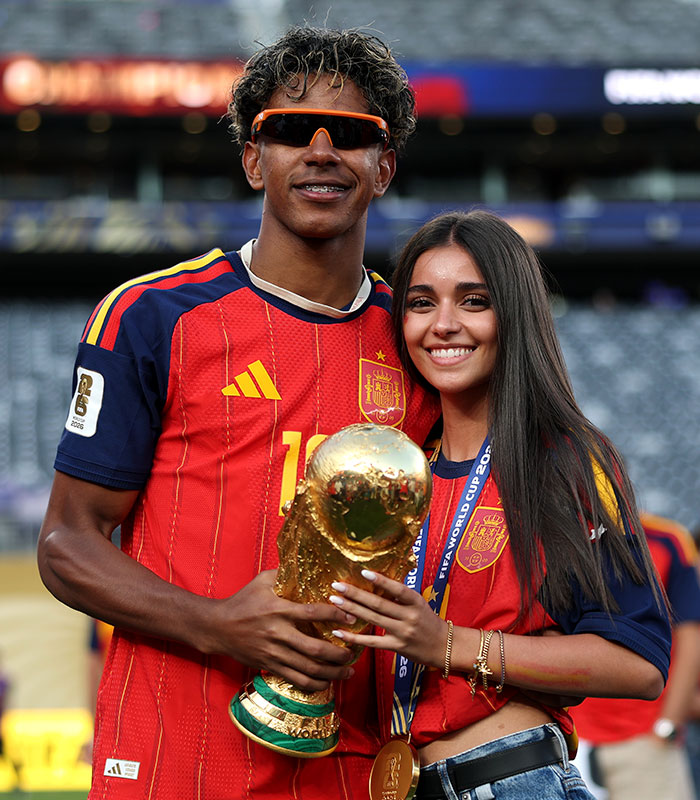 Lamine Yamal with his girlfriend, holding the World Cup trophy after the final win. Lamine Yamal with his girlfriend, holding the World Cup trophy after the final win.