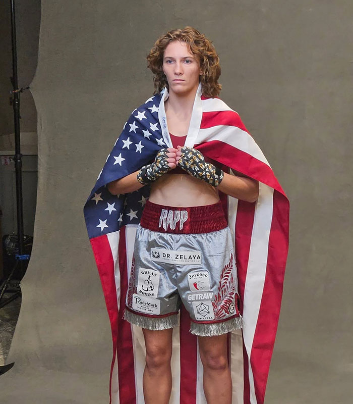 Hannah Rapp draped in an American flag, posing in boxing gear for a memorial tribute.