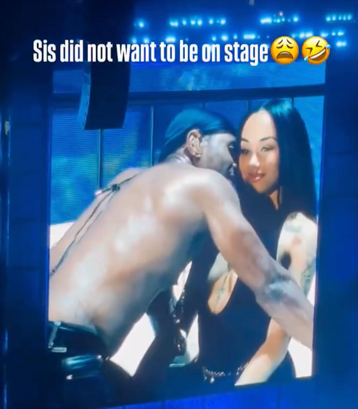 Usher embracing a woman on stage, highlighting her awkward reaction to his seductive moves.