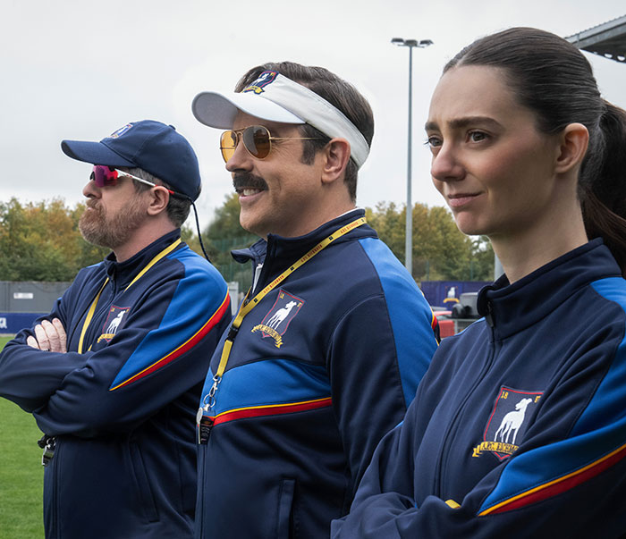 Three coaches on a soccer field, illustrating the ongoing discussion about beauty standards in media.