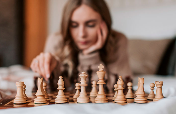 A female chess player in deep thought during a chess game, focusing on the chess community's uproar. A female chess player in deep thought during a chess game, focusing on the chess community's uproar.