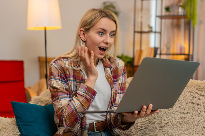 A surprised woman looking at her laptop, realizing her boyfriend is a cheater and deciding about telling his pregnant wife.