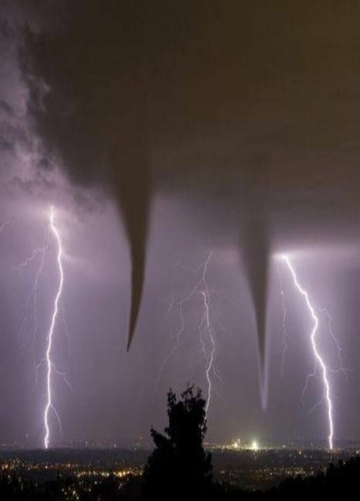 A dramatic night sky with two tornadoes and multiple lightning strikes, one of the fascinating photos of the USA.