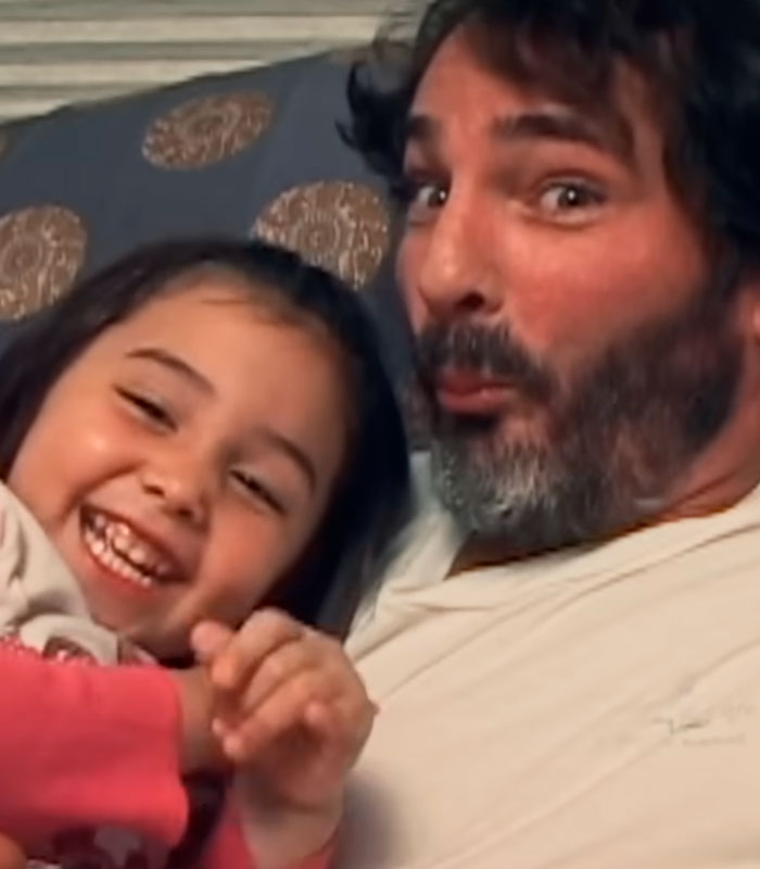 A happy young girl and a man with a beard, portraying a dad with eerie similarities to Charles Manson. A happy young girl and a man with a beard, portraying a dad with eerie similarities to Charles Manson.