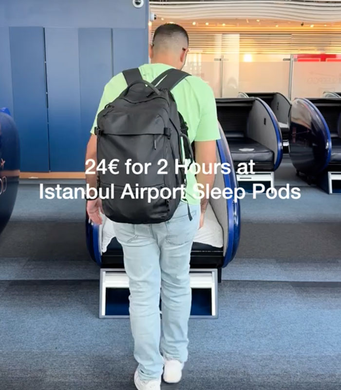 A man with a backpack walking towards an open futuristic sleeping pod in a Chinese airport, showing the cost to travelers. A man with a backpack walking towards an open futuristic sleeping pod in a Chinese airport, showing the cost to travelers.