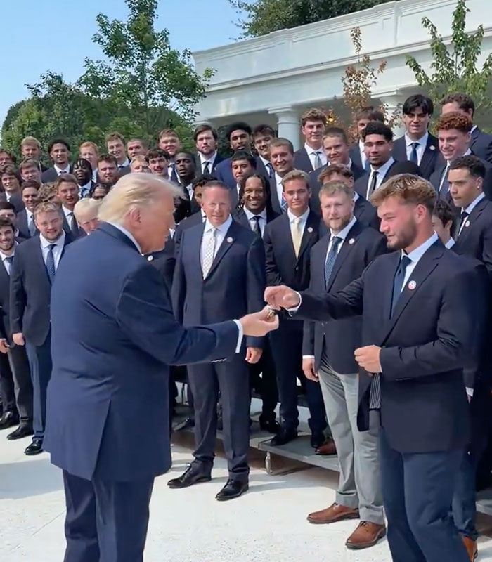 Donald Trump receives an award from a young man, appearing to slip away with it. Donald Trump receives an award from a young man, appearing to slip away with it.