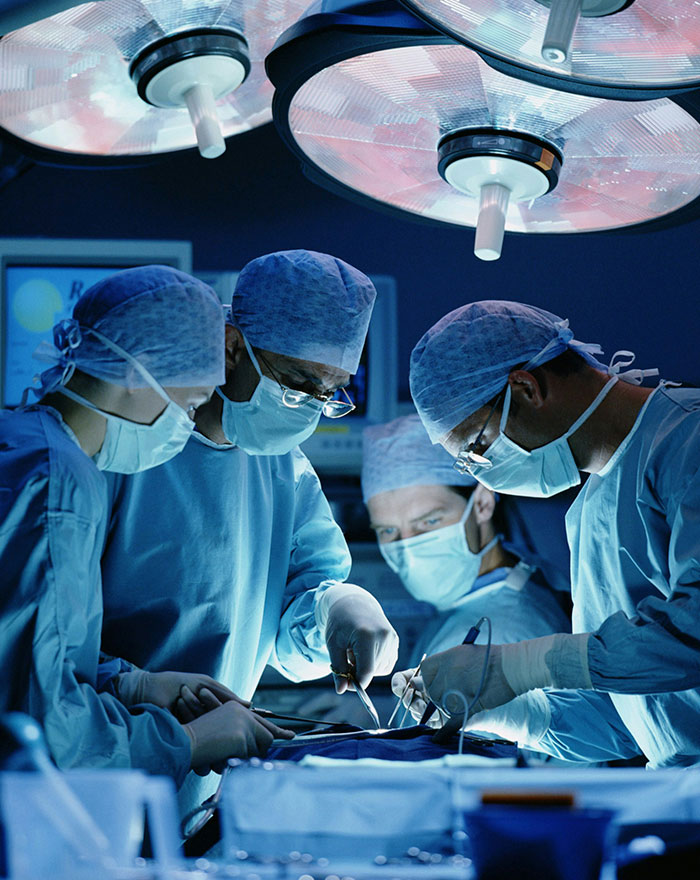 Surgeons perform an operation under bright lights, facing a potential brain cancer horror story.