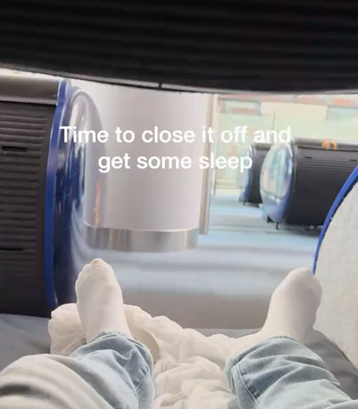 A traveler's feet in white socks inside a futuristic sleeping pod, ready to close it off and get some sleep in the airport. A traveler's feet in white socks inside a futuristic sleeping pod, ready to close it off and get some sleep in the airport.