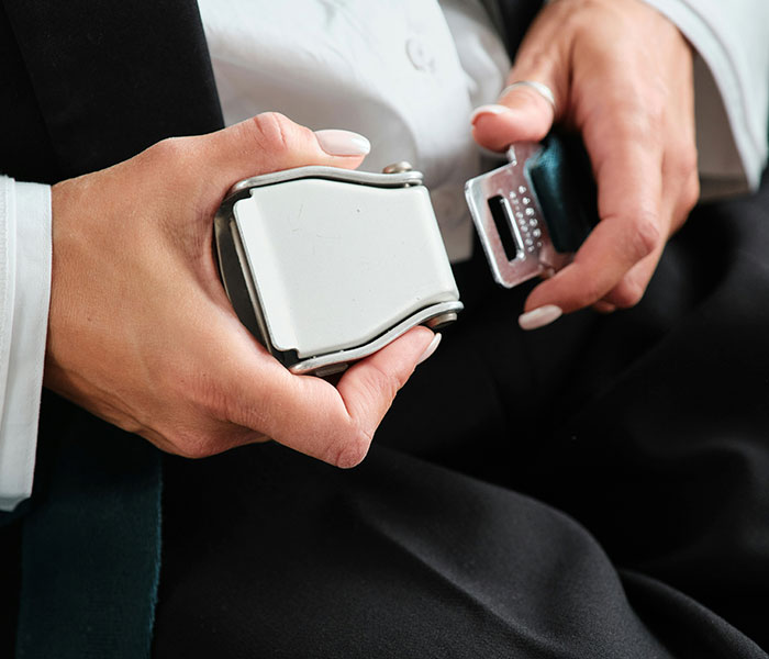 A person fastening a seatbelt, emphasizing safety and preparedness for flights amidst soaring turbulence. A person fastening a seatbelt, emphasizing safety and preparedness for flights amidst soaring turbulence.