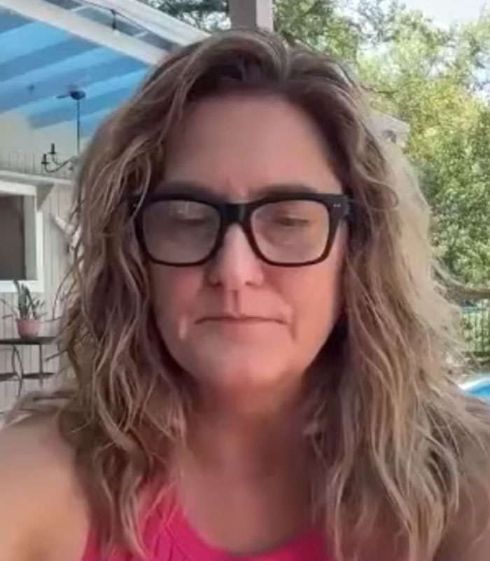 A woman wearing glasses, looking solemn during Hannah Rapp's memorial.