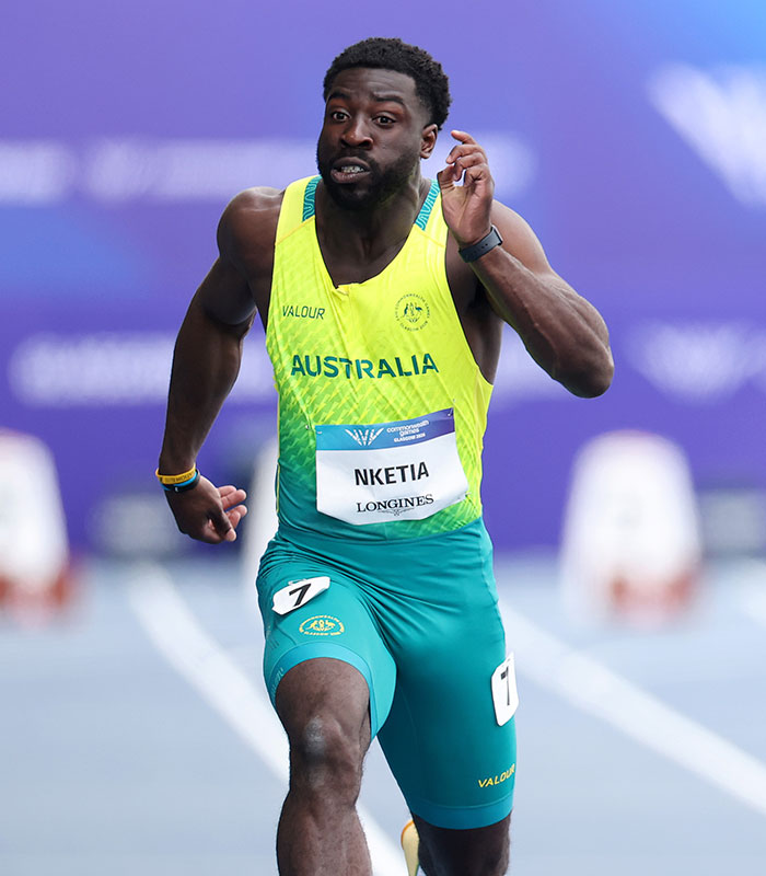 Male sprint star Nketia mid-run, showing the athletic focus despite the controversial rule affecting athletes.