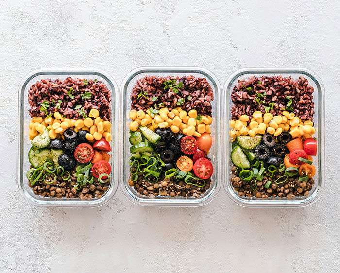 Meal prep containers with healthy food, suggesting methods to achieve different body fat percentages. Meal prep containers with healthy food, suggesting methods to achieve different body fat percentages.