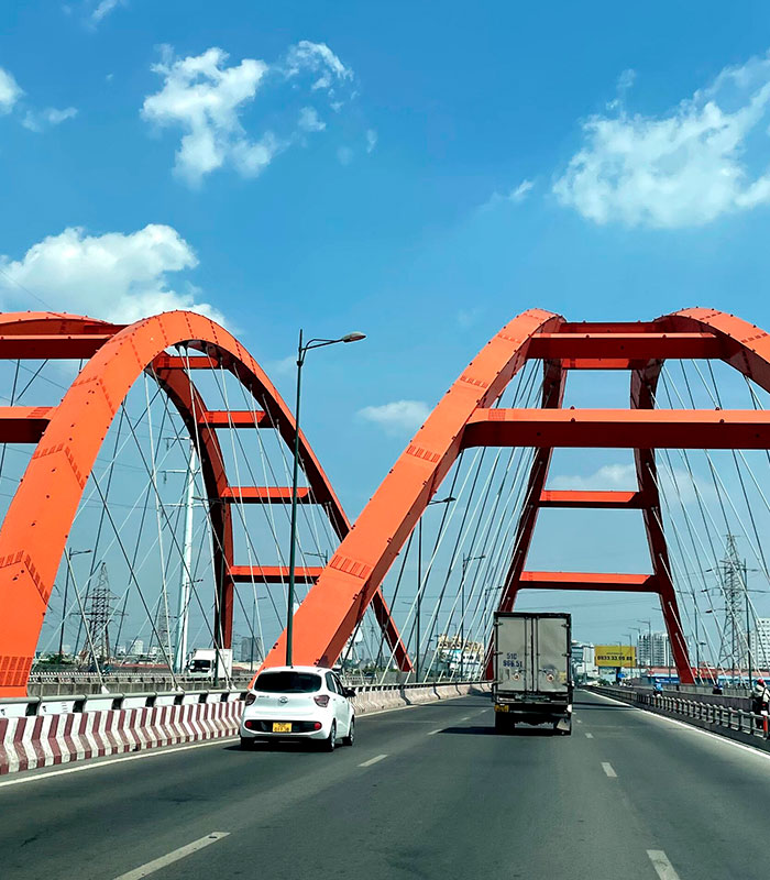 An orange bridge over a highway with cars, under a blue sky, after a claim about human bones. An orange bridge over a highway with cars, under a blue sky, after a claim about human bones.