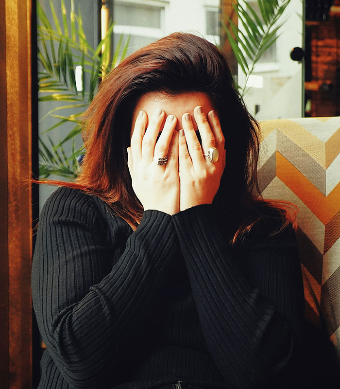 A woman covering her face with her hands, likely feeling publicly shamed after her scheme to accuse a man failed. A woman covering her face with her hands, likely feeling publicly shamed after her scheme to accuse a man failed.