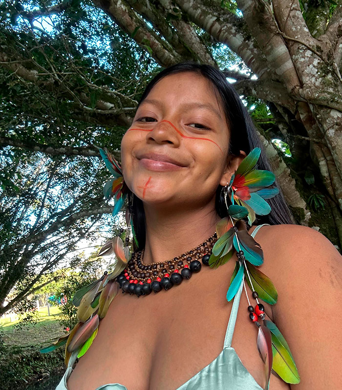 Amazonian woman from a remote tribe, smiling and adorned with traditional feather earrings and necklace. Amazonian woman from a remote tribe, smiling and adorned with traditional feather earrings and necklace.