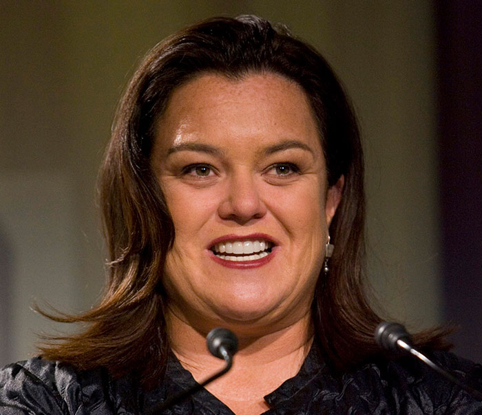 A woman at a microphone, contributing to the conversation about beauty standards and photoshop.