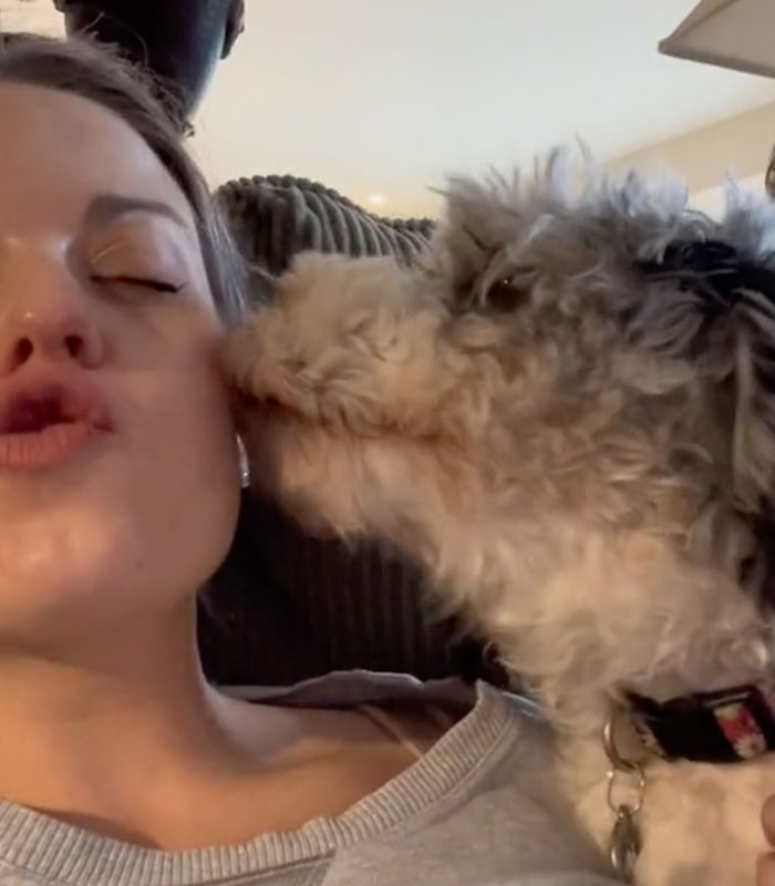 A woman giving a kissy face as a small dog licks her cheek, related to a story about a cheating son-in-law. A woman giving a kissy face as a small dog licks her cheek, related to a story about a cheating son-in-law.