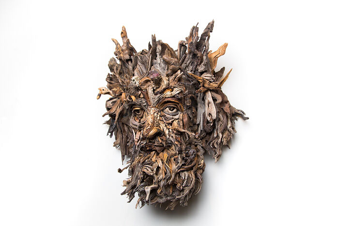 A stunning sculpture made from pieces of wood, resembling a face with intricate details and natural textures.