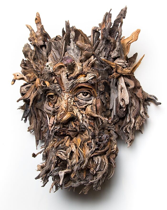A stunning sculpture made from pieces of wood, resembling a face with intricate details and natural textures.