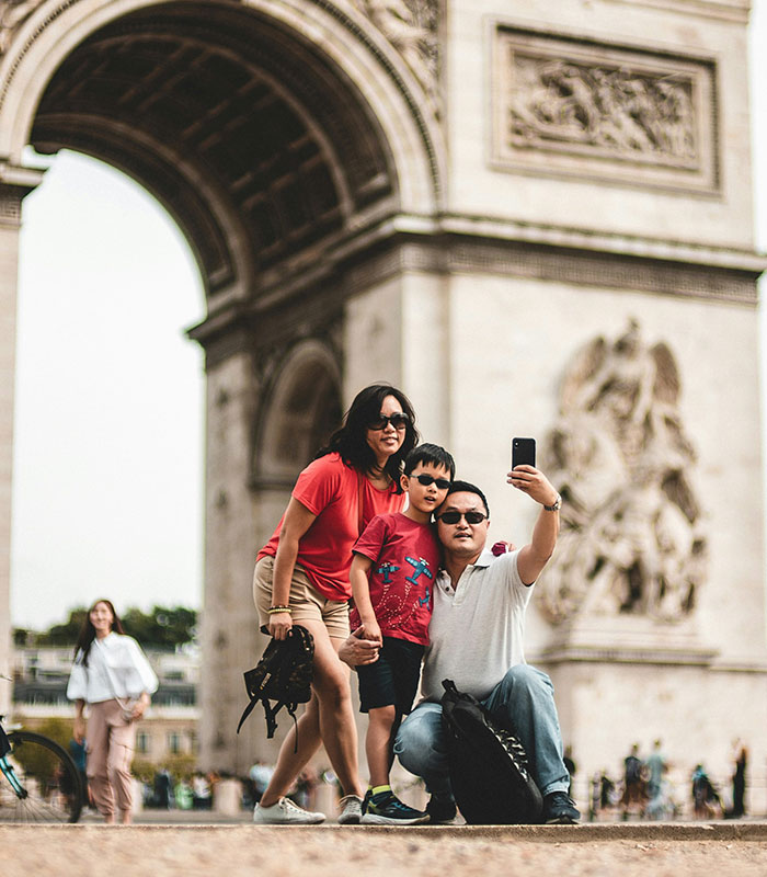 American tourists taking a selfie in front of a monument in Europe.