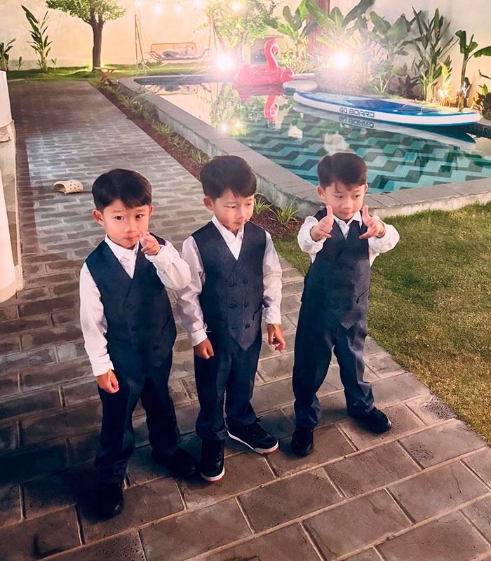 Three young boys dressed in vests and white shirts standing on a patio next to a swimming pool, after a claim about human bones. Three young boys dressed in vests and white shirts standing on a patio next to a swimming pool, after a claim about human bones.