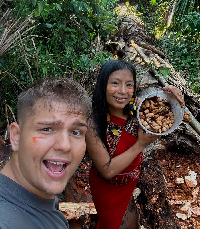 Man with remote tribe, alongside an Amazonian woman holding a bowl of grubs in the jungle. Man with remote tribe, alongside an Amazonian woman holding a bowl of grubs in the jungle.