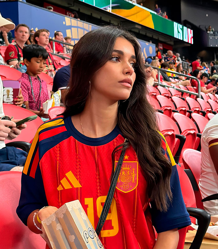 Lamine Yamal's girlfriend in a red jersey with popcorn, watching a game. Lamine Yamal's girlfriend in a red jersey with popcorn, watching a game.
