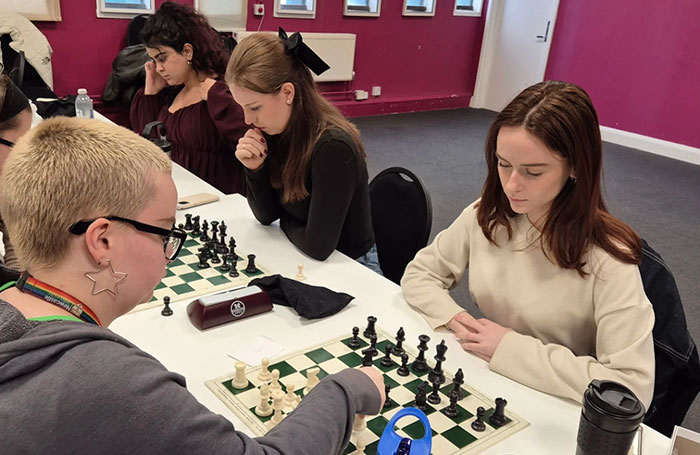Several female chess players engaged in a chess community tournament, concentrating on their games. Several female chess players engaged in a chess community tournament, concentrating on their games.