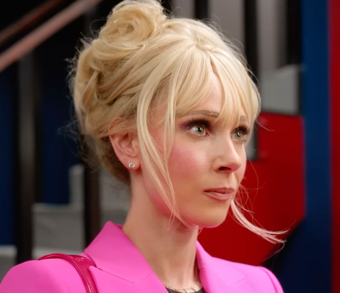 Woman in a pink jacket, her image often subject to discussions on beauty standards and heavy photoshop.