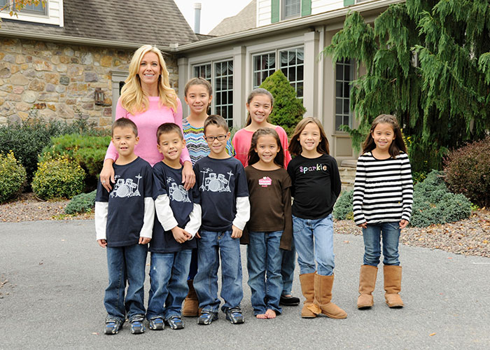 Kate Gosselin and her children, including Collin Gosselin, standing outside a large house.