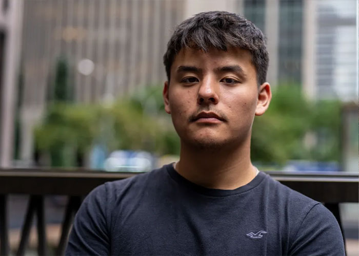 A serious-looking Collin Gosselin in a dark t-shirt against a blurred urban background.