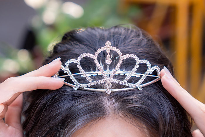 A girl wearing a tiara, representing kids who might have unfortunate names due to parental choices.