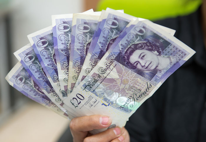 A hand holding several twenty-pound notes, symbolizing success or rewards from clever comebacks.