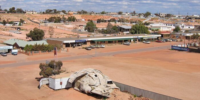 A landscape image showing an urban area with a UFO replica. The image provides curious facts about the area.