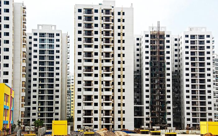 Multiple tall white apartment buildings under construction, illustrating curious facts about urban development.